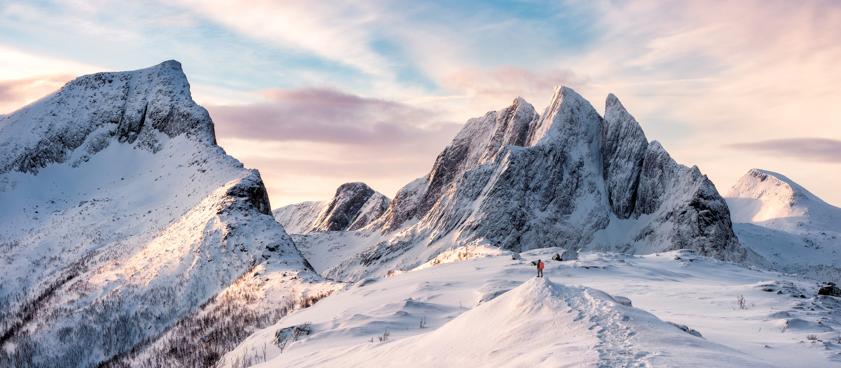 Panorama of Mountaineer standing on top of snowy mountain range